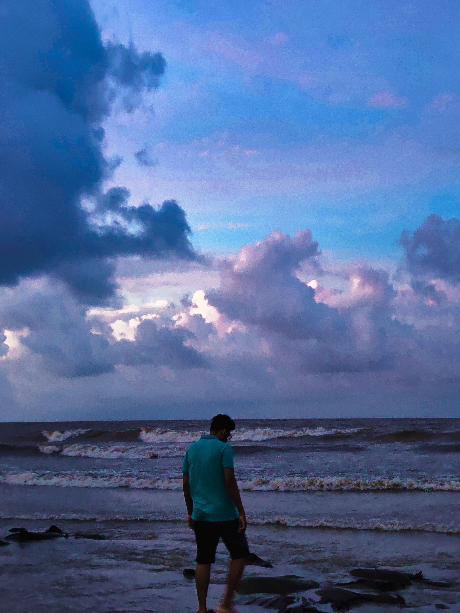 Rabbin Zaman looking out at the sea at dusk.